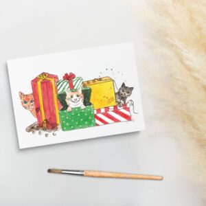 Foto van een kerstkaart met aquarel schildering met katten in cadeaus